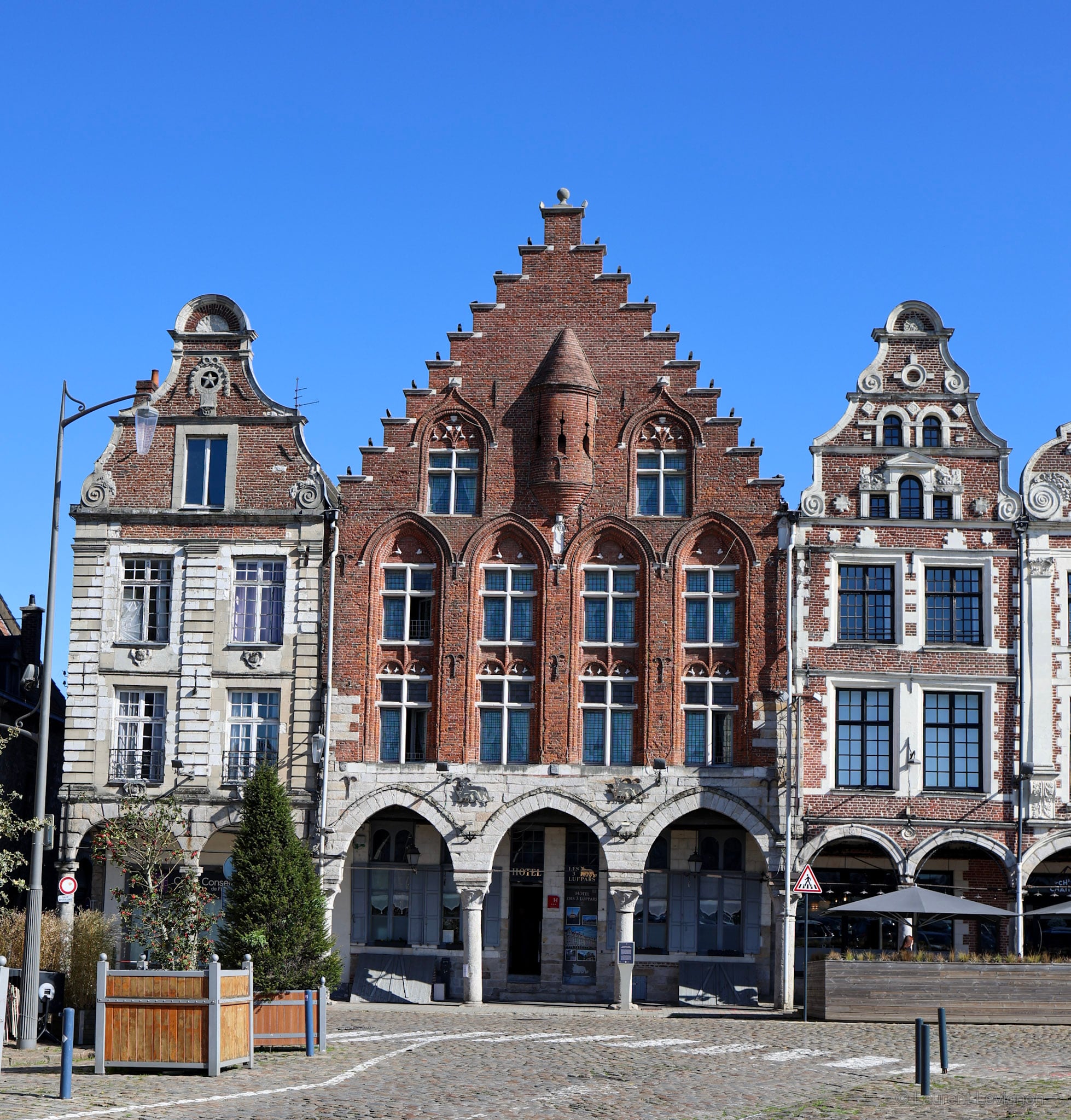 Grand'Place d'Arras, avril 2026. Bâtie en 1467, c'est la plus ancienne maison de la ville et le seul pignon à gradins parmi les baroques flamands ; son alignement a servi de modèle à toute la place.