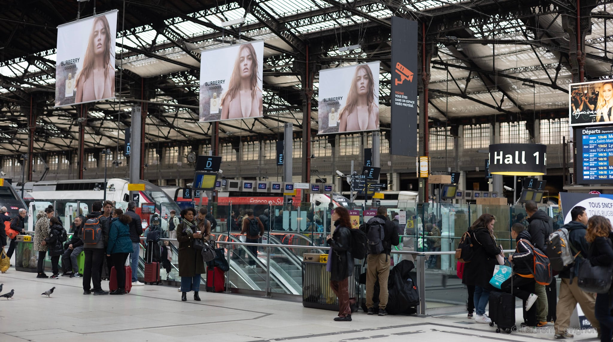 Gare de Lyon, Hall 1, novembre 2023. Trois fois la même affiche sous la charpente de 1900, et personne ne lève les yeux.