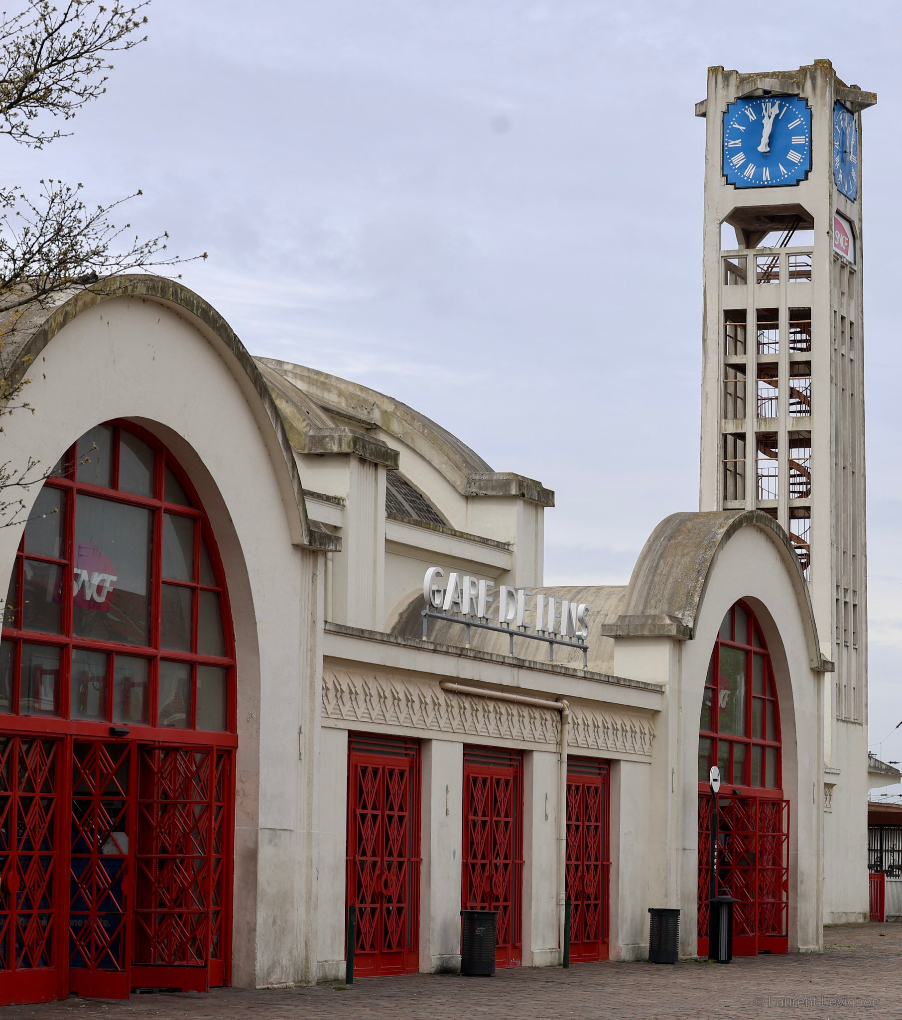 Urbain Cassan, 1927. Le bâtiment figure une locomotive : la tour de 23 mètres pour cheminée, les voûtes pour roues. Les grilles rouges sont d'Edgar Brandt.