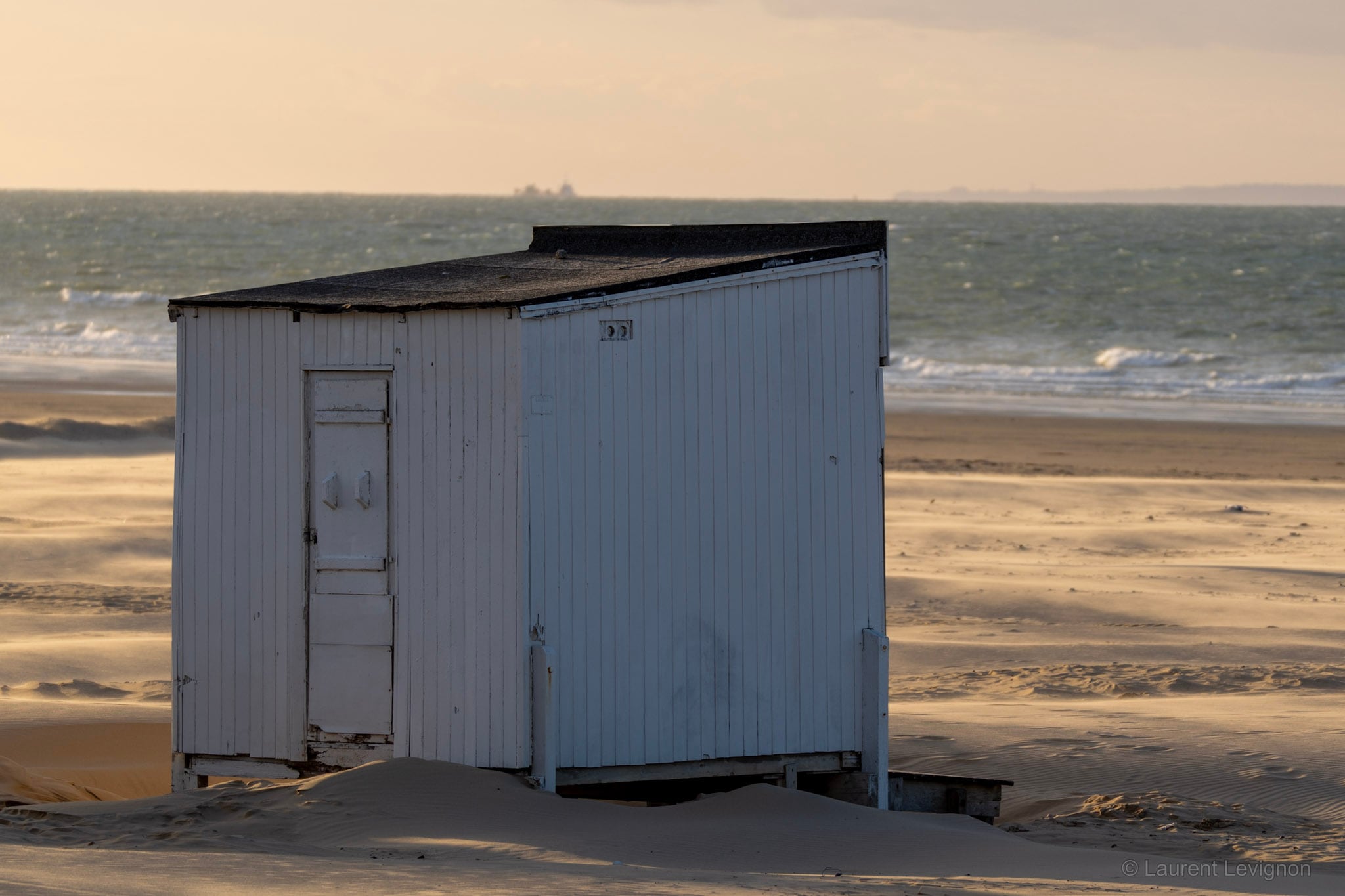 Un chalet de la plage de Calais, à moitié recouvert par le sable qu’apporte le vent, le 10 octobre 2026 en fin de journée.