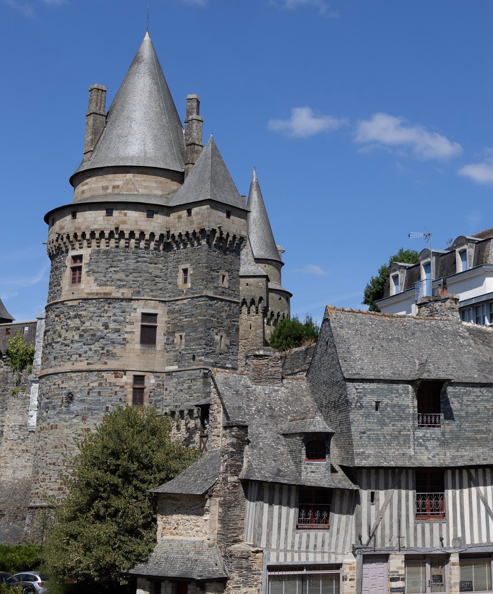 Tours des XIIIe–XVe siècles et maison à pans de bois couverte d'ardoise, août 2026.