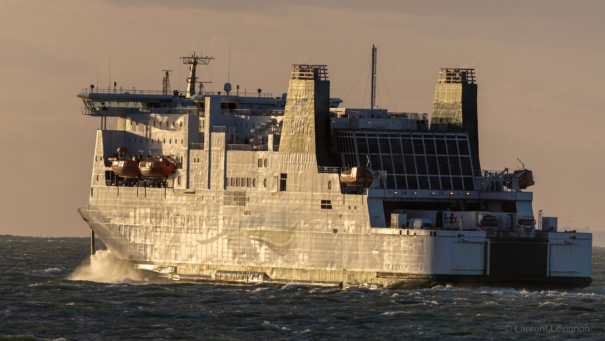 Un ferry quitte Calais par mer agitée, sa coque éclairée par le soleil rasant, le 10 octobre 2026 en fin de journée.