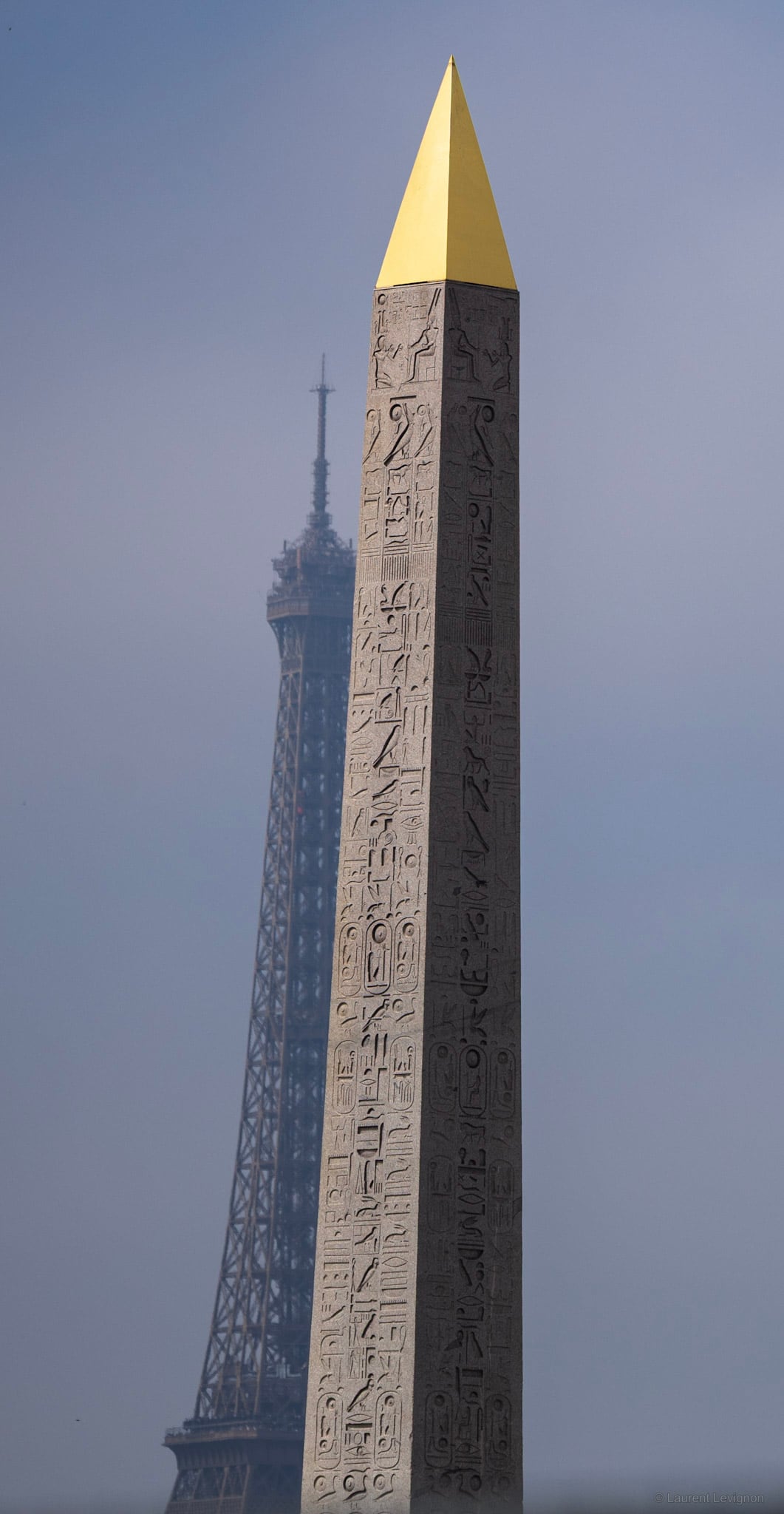 Place de la Concorde. L'obélisque de Louxor, 3 300 ans, dressé ici en 1836 ; sa pointe dorée date de 1998. Derrière, la tour Eiffel dans la brume.